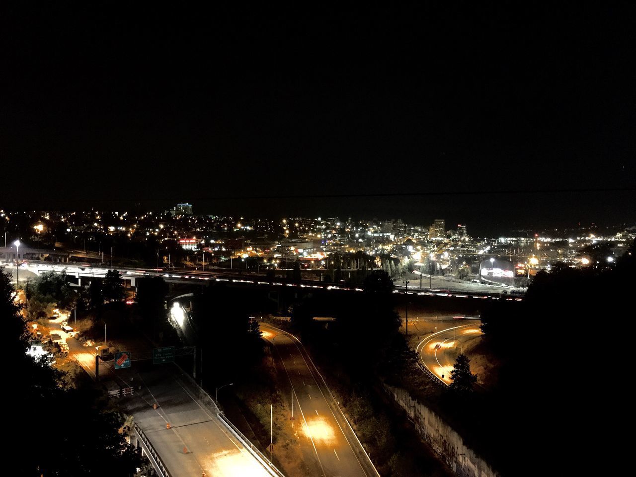 HIGH ANGLE VIEW OF ILLUMINATED CITY AT NIGHT