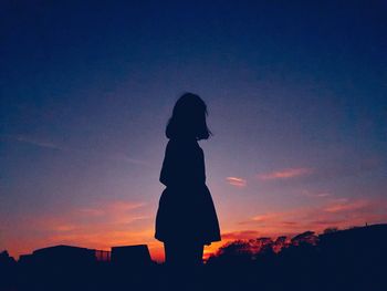 Silhouette woman standing against sky during sunset