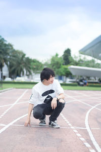 Rear view of boy sitting on floor