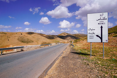 Road sign against sky