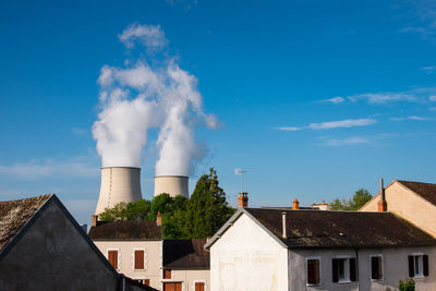 Smoke emitting from chimney against sky