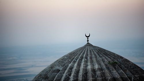 High section of mosque against sky at sunset