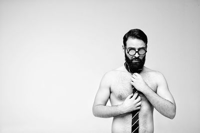 Portrait of young man standing against white background