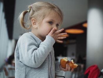 Girl eating doughnut at home