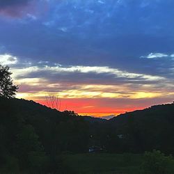 Scenic view of dramatic sky over silhouette landscape