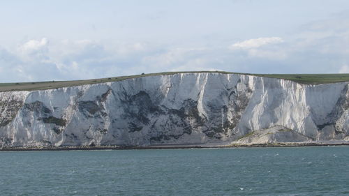 Scenic view of sea and mountain against sky