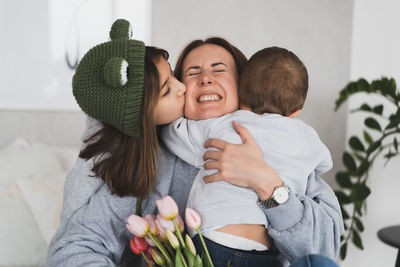 Portrait of mother carrying daughter at home