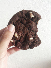 Close-up of hand holding chocolate cake