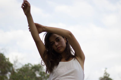 Portrait of young woman against sky