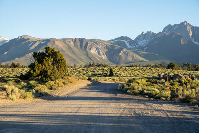 Road leading towards mountains against sky