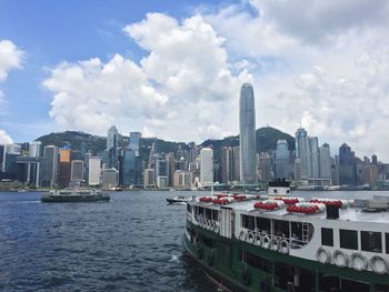 City skyline by sea against sky