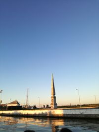 River amidst buildings against clear blue sky