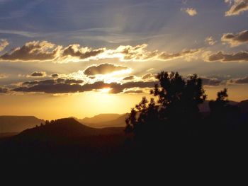 Scenic view of silhouette mountains against sky at sunset