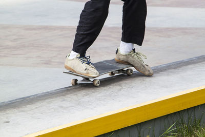 Low section of man skateboarding on retaining wall