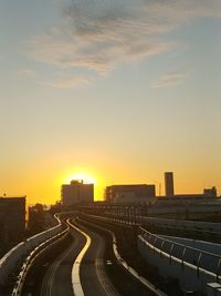 High angle view of road by buildings against sky during sunset