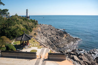 Lighthouse by sea against sky