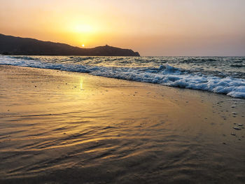 Scenic view of beach against sky during sunset