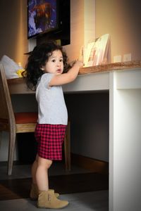 Girl looking away while standing on floor at home