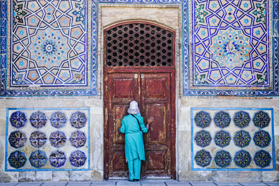 Full length of man standing against wall in building