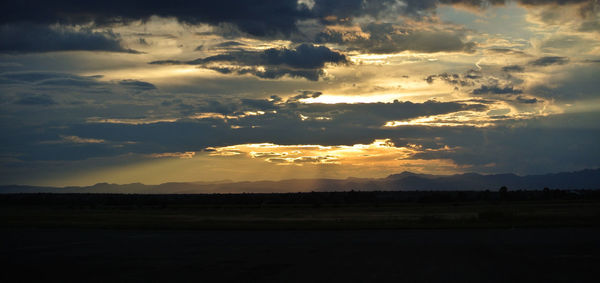 Scenic view of storm clouds over silhouette landscape