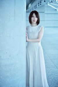 Portrait of young woman standing against wall