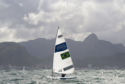 Information sign by sea against sky