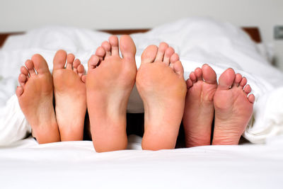 Close-up of bare feet in bed