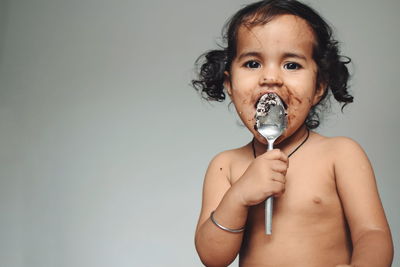 Close-up portrait of shirtless baby girl over white background