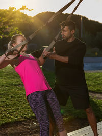 Man helping woman in exercising