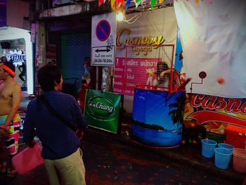 Rear view of man walking on street in city