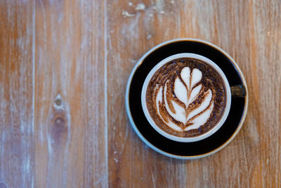 A coffee cup placed on a wooden table. top view