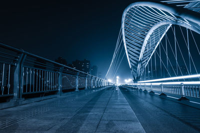 Illuminated bridge against sky at night