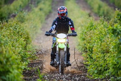 Woman riding her dirt-bike through plantation in pak chong / thailand