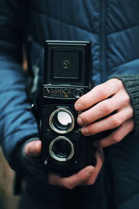 Midsection of man photographing with camera