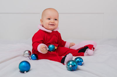 Portrait of cute boy playing with toys on bed at home