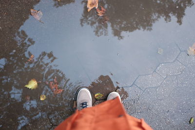 Low section of man standing in puddle