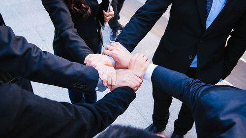 High angle view of business people forming hand chain