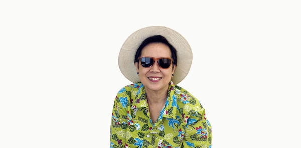 Portrait of smiling young woman standing against white background