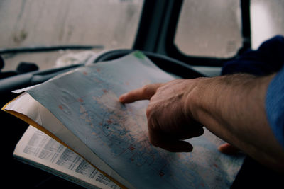 Cropped hand of man holding book