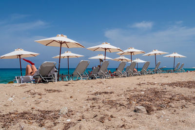 Traditional windmill on beach against sky