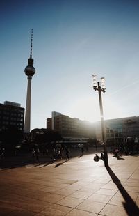 Communications tower in city against clear sky