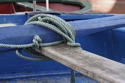 Close-up of rope tied to boat moored at harbor