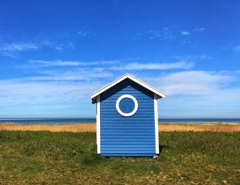 Information sign on field by sea against sky