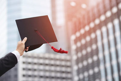 Close-up of hand holding umbrella against blurred background