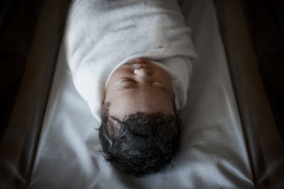 Close-up of baby sleeping on bed