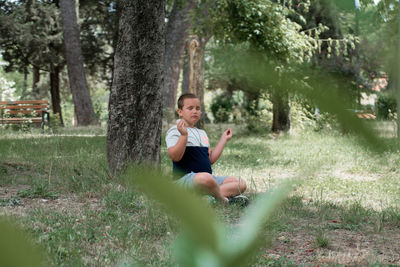 Portrait of smiling young woman sitting on land