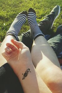 Cropped image of person holding umbrella on grassy field