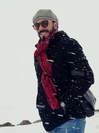 Man with umbrella standing in snow