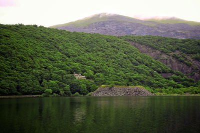Scenic view of lake by mountains against clear sky