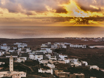 High angle view of townscape by sea against sky